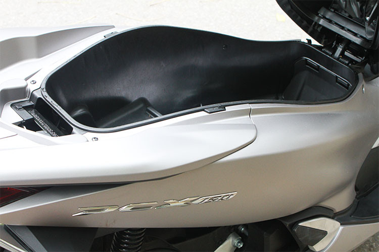 Phát huy ưu điểm của thế hệ trước, PCX phiên bản mới vẫn sở hữu khoang chứa đồ rất rộng với khả năng để 1 mũ bảo hiểm cả hàm ở phần dưới và vẫn còn thừa ra khá nhiều chỗ trống phía trên. Tay xách phái sau thiết kế lớn, liền mạch với tổng thể của chiếc xe cho cảm giác mạnh mẽ.