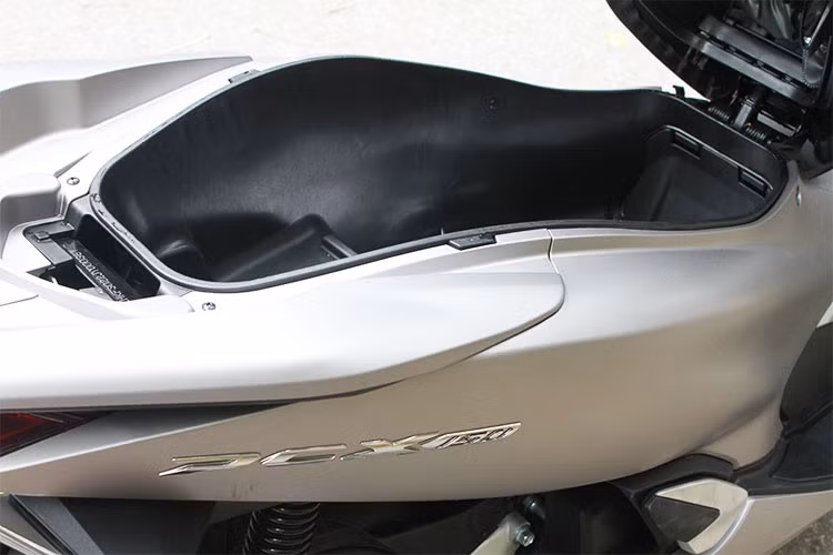 Phát huy ưu điểm của thế hệ trước, PCX phiên bản mới vẫn sở hữu khoang chứa đồ rất rộng với khả năng để 1 mũ bảo hiểm cả hàm ở phần dưới và vẫn còn thừa ra khá nhiều chỗ trống phía trên. Tay xách phái sau thiết kế lớn, liền mạch với tổng thể của chiếc xe cho cảm giác mạnh mẽ.