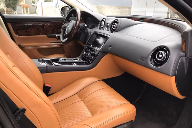 Nội thất của Jaguar XJL 2014 nổi bật với chất liệu da bọc cao cấp, vô-lăng, thành cửa được ốp gỗ tinh tế. Chính giữa bảng điều khiển của xe là màn hình cảm ứng kích thước 8 inch, phía trên là 2 cửa điều hòa thiết kế ấn tượng đi kèm đồng hồ kim gắn logo XJ bên trong.