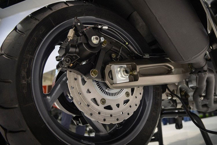 Đặc biệt thiết kế hệ truyền động của AK 550 tách rời động cơ khỏi hệ thống treo, thay vì gộp chung như kiểu xe tay ga chúng ta thường thấy. Điều này giúp giảm đáng kể phần trọng lượng của hệ thống treo, trong kỹ thuật gọi là unsprung weight. Việc giảm unsprung weight sẽ giúp hệ thống treo cần ít năng lượng hơn để phân tác lực.