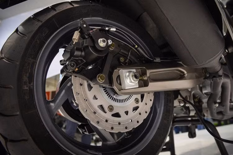 Đặc biệt thiết kế hệ truyền động của AK 550 tách rời động cơ khỏi hệ thống treo, thay vì gộp chung như kiểu xe tay ga chúng ta thường thấy. Điều này giúp giảm đáng kể phần trọng lượng của hệ thống treo, trong kỹ thuật gọi là unsprung weight. Việc giảm unsprung weight sẽ giúp hệ thống treo cần ít năng lượng hơn để phân tác lực.