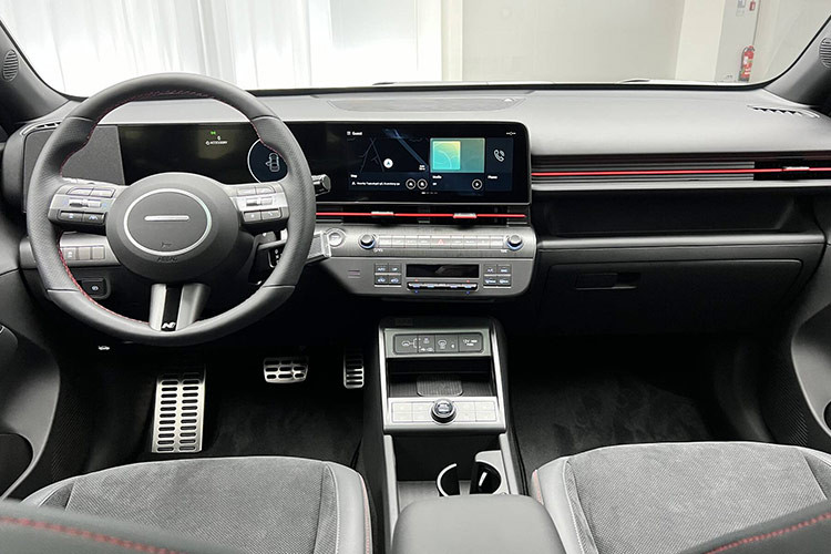 Bên trong cabin, Hyundai Kona Electric 2024 vẫn mang thiết kế như trên bản thường với phong cách hiện đại và kỹ thuật số hóa. Theo đó, xe được trang bị màn hình cong, kết hợp bảng đồng hồ kỹ thuật số và màn hình cảm ứng trung tâm đều có kích thước 12,3 inch. Cần chuyển số điện tử nay được bố trí sau vô-lăng tạo thêm sự gọn gàng hơn. Trong khi núm xoay chọn chế độ lái được đặt ở trên cụm điều khiển trung tâm.