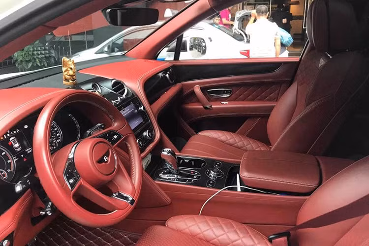 Bên trong khoang lái chiếc Bentley Bentayga độ khủng nhất Việt Nam là "nội y" màu đỏ đun, màu sắc này bao trùm cả khoang lái, từ ghế ngồi, trần xe, dây đai an toàn cho đến ngay cả thảm sàn. Điểm nhấn bên trong khoang lái có thế kể đến các chi tiết bằng nhôm, sợi carbon bóng ở viền bảng đồng hồ, bệ cần số và gỗ.