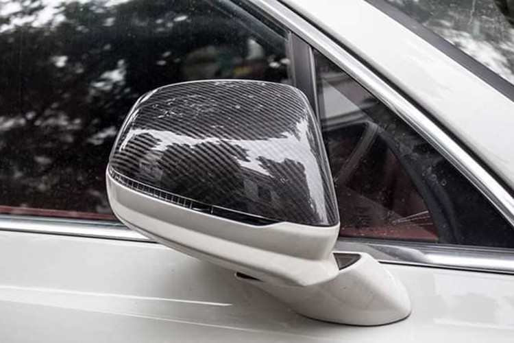 Cụ thể, hần đầu của chiếc Bentley Bentayga được trang bị thêm với 1 cánh lướt gió cố định cỡ lớn và tấm ốp hai bên đèn sương mù bằng sợi carbon. Bên hông xe cũng nhận được sự nâng cấp đáng kể so với xe nguyên bản bao gồm cánh lướt gió và vỏ gương bằng sợi carbon.