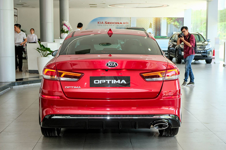 Ở phía sau, cụm đèn hậu của bản nâng cấp Kia Optima 2019 được thiết kế lại với đồ họa chiếu sáng mới sắc nét và tinh tế hơn, bổ sung hai tấm phản quang. Bộ khuếch tán khí động học được sơn đen bóng, có thêm thanh mạ chrome. Hai ống xả hình oval cỡ lớn được đặt đối xứng nhau.