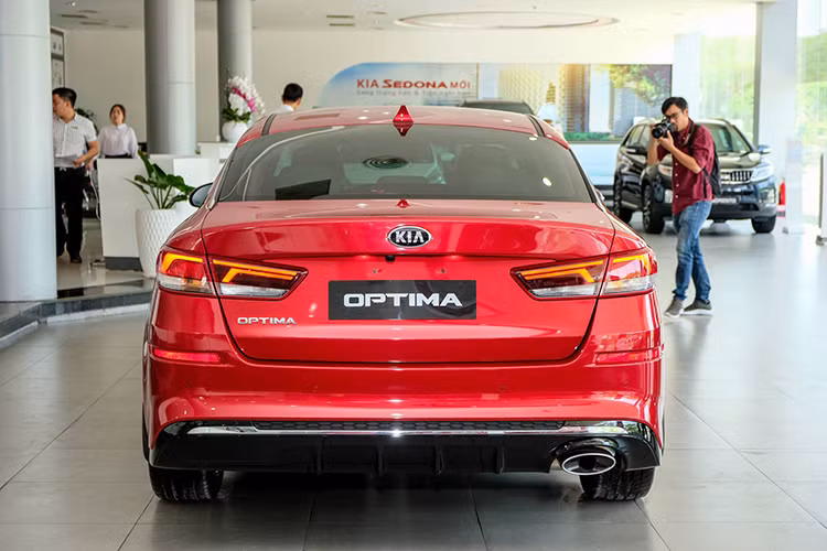 Ở phía sau, cụm đèn hậu của bản nâng cấp Kia Optima 2019 được thiết kế lại với đồ họa chiếu sáng mới sắc nét và tinh tế hơn, bổ sung hai tấm phản quang. Bộ khuếch tán khí động học được sơn đen bóng, có thêm thanh mạ chrome. Hai ống xả hình oval cỡ lớn được đặt đối xứng nhau.