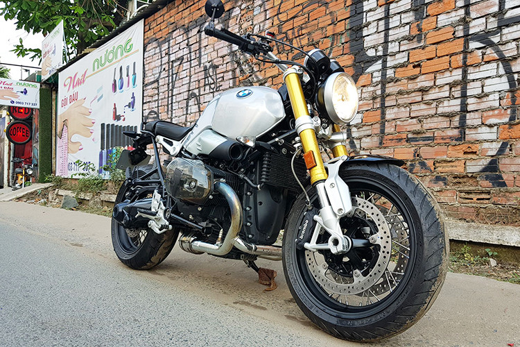 Chủ nhân của chiếc xe môtô BMW R nine T trong bài viết này đang sống tại TP HCM. Với mong muốn chiếc xe trở nên cá tính hơn mà không mất đi vẻ đẹp hoài cổ nguyên bản, anh đã chỉ trang bị cho chiếc xe một số đồ chơi đơn giản nhưng độc đáo - đặc biệt nhất là cụm lốc máy trong suốt của thương hiệu Wunderlich đến từ Đức.