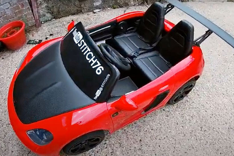 Chiếc xe đồ chơi chạy phố ở đây không phải là xe đồ chơi Power Wheels, nhưng nó là một sản phẩm tương tự: một chiếc xe đồ chơi Super Sport XXL, còn được tiếp thị là xe Super Car XL hoặc YSA-021.