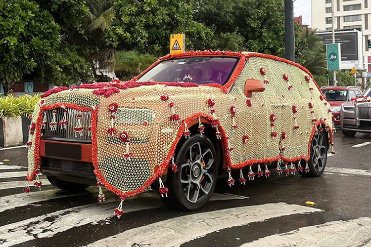 Cũng có hoa trên xe SUV Rolls-Royce Cullinan siêu sang, nhưng điều gây chú ý là một lớp trông như rèm phủ kín toàn thân xe, với tông màu vàng và viền đỏ. Thậm chí, có người cho rằng nếu đó là vàng thật thì cũng không có gì ngạc nhiên.