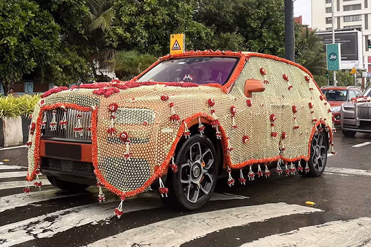 Cũng có hoa trên xe SUV Rolls-Royce Cullinan siêu sang, nhưng điều gây chú ý là một lớp trông như rèm phủ kín toàn thân xe, với tông màu vàng và viền đỏ. Thậm chí, có người cho rằng nếu đó là vàng thật thì cũng không có gì ngạc nhiên.