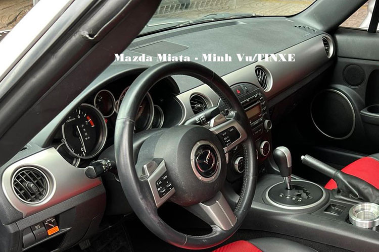 Bên trong khoang lái, Mazda MX-5 Miata bản nâng cấp giữa vòng đời có bảng điều khiển với các tính năng tối hơn và đồ họa được thiết kế lại cho đồng hồ đo. Để tạo thêm không gian để chân trong cabin, phần lồi ra khỏi các túi cửa đã được loại bỏ. Xe của ông Vũ có nội thất 2 màu đỏ đen, doanh nhân này độ thêm hộc để đựng khay cà phê và tàn xì gà, 2 bảo bối tối quan trọng luôn đi theo doanh nhân này. 