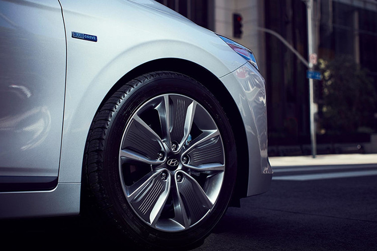 Bộ vành hợp kim 17 inch 5 chấu bản to là một trong những đặc trưng của dòng xe Ioniq, được duy trì từ thế hệ trước. Phía sau bộ vành có vẻ ''thô kệch'' này là công nghệ tái tạo năng lượng điện thông minh từ phanh của Hyundai - Smart Regenerative Braking. Huy hiệu Blue Drive của dòng xe xanh này được đặt phía trên hốc bánh trước.