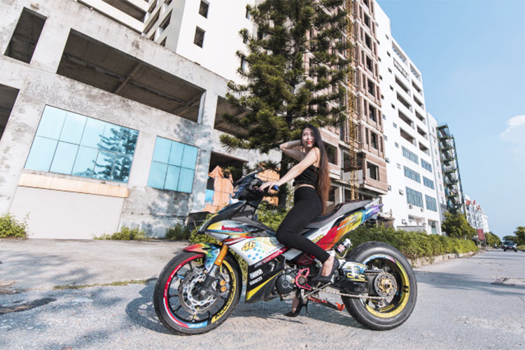 Được biết, chiếc Yamaha Exciter 150 độ khủng với option môtô phân khối lớn này của một biker tại Hà Nam. Đầu tiên phải kể đến dàn áo của xe, nó được chủ nhân trang bị khá sặc sỡ với nhiều sắc màu nổi bật, kết hợp với logo của tay đua mang thương hiệu 46 - Valentino Rossi.