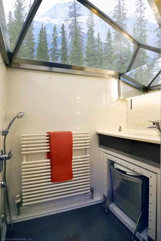 Khu vực "nhà tắm" có "cửa sổ trời" để tận dụng ánh sáng thiên nhiên, tiết kiệm nhiên liệu và khiến không gian thoáng đãng hơn. Có thể thấy một bồn cầu vệ sinh được cất giấu khá tinh tế trong phòng tắm di động này.