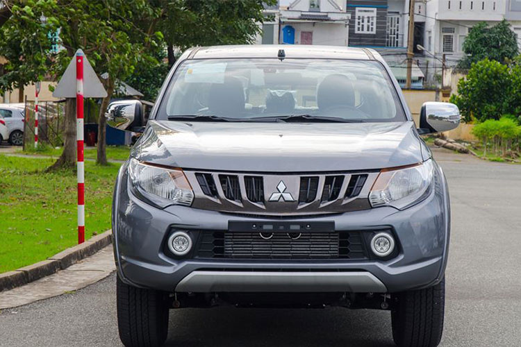 Phần đầu xe nổi bật với cụm ca-lăng màu titan cá biệt thay vì chrome như bản cũ, tạo hình các thanh nan kéo chụm dưới logo hãng dạng hình chữ V trông mạnh mẽ và cứng cáp hơn. Cụm đèn pha ở phiên bản cao cấp nhất 4x4 AT MIVEC chỉ là đèn Halogen, phiên bản 4x4 MT lại được trang bị đèn pha tự động Bi-xenon kiểu Projector. Cụm đèn sương mù sử dụng bóng LED, cản trước cũng không thay đổi ngoài màu sơn.