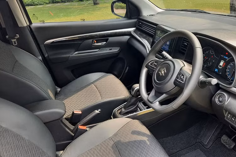 Bên trong Suzuki XL7 Hybrid 2023 vẫn là không gian nội thất 7 chỗ như trước nhưng phối màu xám - đen mới, đi kèm những chi tiết ốp gỗ bóng màu đen. Mẫu MPV này có thêm một số trang bị như gương chiếu hậu kỹ thuật số cảm ứng ở bản Alpha và hệ thống kiểm soát hành trình.