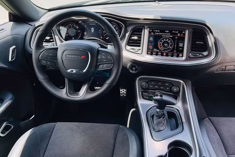 Bên trong khoang nội thất, Dodge Challenger 2021 mới tiếp tục thể hiện sự cơ bắp với tâm điểm là hệ thống màn hình trung tâm nối liền cụm đồng hồ lái. Thiết kế của xe theo xu hướng thể thao nên sẽ không quá sang trọng ở đây. Tuy nhiên, cách bố trí mọi chi tiết đều hướng về người lái giúp việc điều khiển xe dễ dàng hơn.