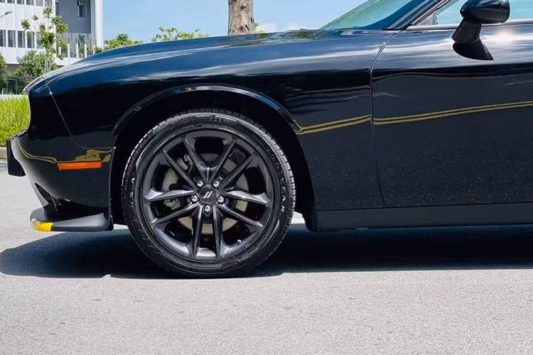 "Dàn chân" xe Dodge Challenger 2021 tạo hình cánh hoa 5 chấu kép với kích thước 19 inch kết hợp cùng bộ lốp 235/55R19, tay nắm cửa mang phong cách cổ điển nhưng được kết hợp với nút bấm mở cửa thông minh. Gương chiếu hậu xe được đặt tách biệt trụ A, đồng màu với thân xe. Dù có những tính năng hiện đại như cảnh báo điểm mù, sấy gương, chỉnh điện nhưng không tích hợp đèn xi-nhan.