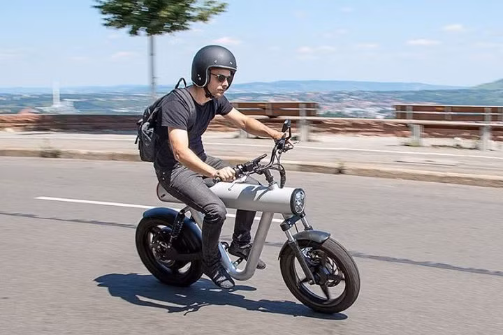 Mẫu xe máy điện được thiết kế từ nước Đức này đã được tối giản hóa với việc chỉ sở hữu các bộ phận cần thiết nhất để sử dụng như yên xe, tay lái tracker trên hai cặp giảm xóc nối với các bánh xe cùng bộ phanh đĩa. Tất cả bộ phận được dấu trong một bộ ống trụ được đặt như gióng xe.