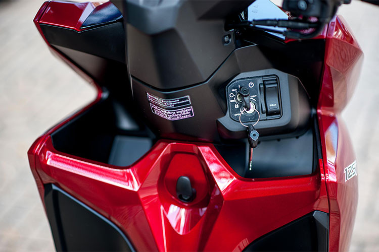 Phanh sau của xe có lẫy khóa giúp đỗ xe ngang dốc. Đáng tiếc trên phiên bản Click 125 mới này không được trang bị chìa khoá thông minh Smartkey - chống trộm mà vẫn là khoá từ đa dụng. Phía trước người lái là hai hộc đựng đồ lặt vặt khá tiện dụng, đặc biệt là dành cho phái đẹp.