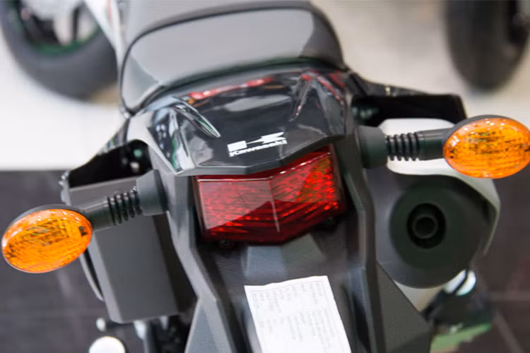 Cũng giống như phấn đầu, cụm đèn sau Kawasaki D-Tracker 150 được thiết kế vuốt nhọn và sử dụng bóng halogen. Xi nhan trước và sau của xe thiết kế đơn giản nhưng được trang bị thêm thanh cao su chống gãy.