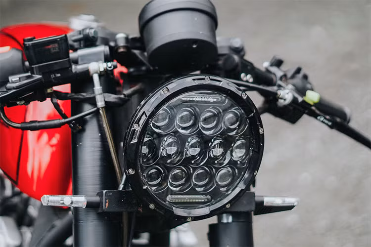 Trên chiếc Honda CB750 đời 1981 này, nó được xưởng độ Tự Thanh Đa làm mới bằng cách tối giản các chi tiết, hệ thống khung sườn gọn nhẹ hơn. Nằm giữa cặp phuộc trước là đèn pha LED dạng thấu kính, xi nhan led nhỏ hiện đại và báo sáng tốt hơn so với bóng halogen nguyên bản.