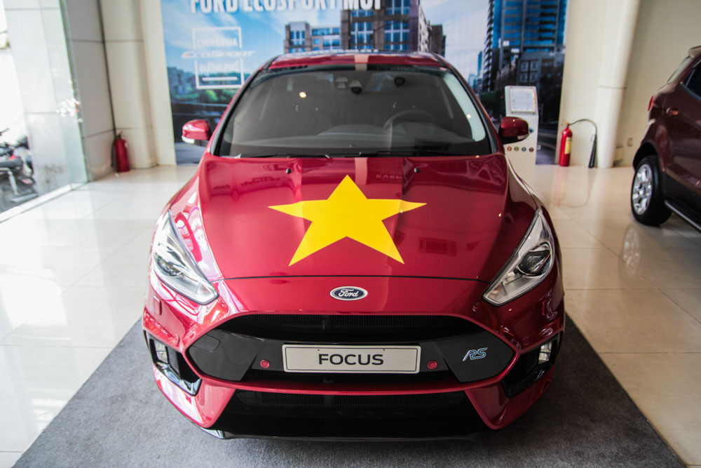 Không khí cổ vũ cho Olympic Việt Nam cũng lan tỏa đến các showroom xe. Một đại lý của Ford tại quận 3, TP.HCM trưng bày 2 mẫu Ford Focus RS và Ford EcoSport với biểu tượng quốc kỳ.