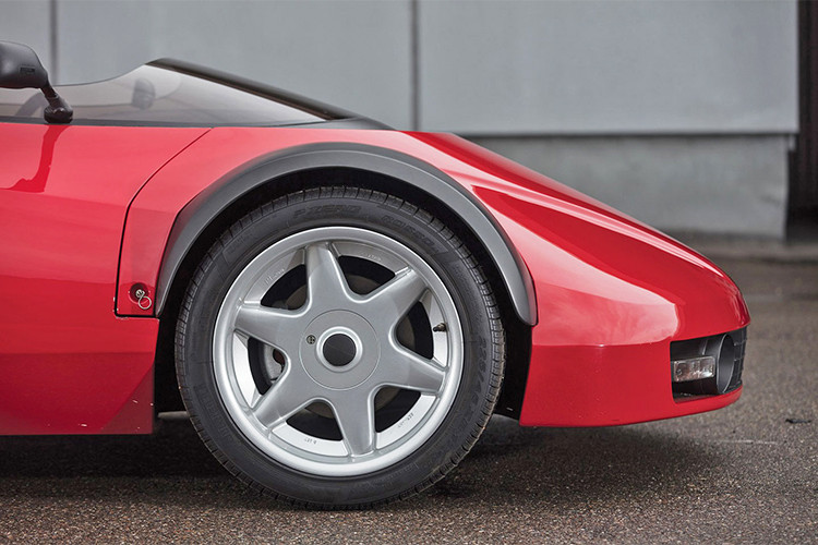 Tên của chiếc xe độc nhất vô nhị này thường được gọi là siêu xe Ferrari Conciso (tạm bỏ qua thương hiệu Lotus). Nó sở hữu phần khung xe tự chế và được thiết kế dựa theo nguyên lý phát triển của mẫu siêu xe đàn anh Ferrari 328 GTS vào năm 1989 với hình dáng xe không cửa. 