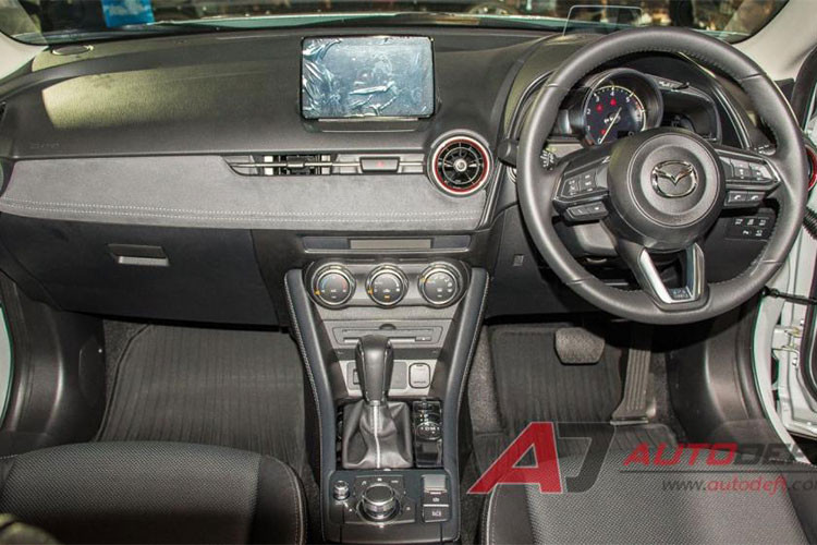 Bước vào bên trong, nội thất của CX-3 2018 sẽ chào đón bạn bằng một không gian hiện đại và cải tiến hơn đáng kể. Đầu tiên phải kể đến sự bổ sung mới mẻ của hệ thống phanh đỗ xe điện tử có tính năng giữ phanh tự động, thay thế cho đơn vị hoạt động thủ công trên mẫu xe trước kia.