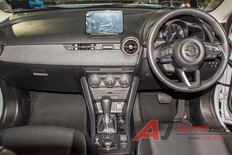 Bước vào bên trong, nội thất của CX-3 2018 sẽ chào đón bạn bằng một không gian hiện đại và cải tiến hơn đáng kể. Đầu tiên phải kể đến sự bổ sung mới mẻ của hệ thống phanh đỗ xe điện tử có tính năng giữ phanh tự động, thay thế cho đơn vị hoạt động thủ công trên mẫu xe trước kia.