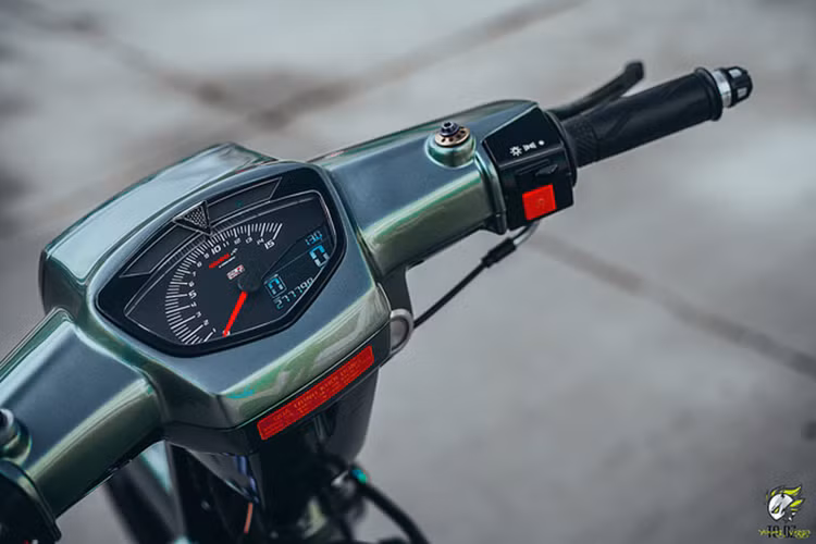 Cụ thể, chiếc xe máy Honda Dream II này được độ kiểng lại khá nhiều đồ chơi - phần đầu của chiếc xe với tay thắng CRG RC2, phần nhựa đã được cắt gọt khá tinh tế để phù hợp bộ tay thắng hàng hiệu, cùng với đó là cặp bao tay Yamaha + gù CNC thủ công với chi tiết sắc nét và góc cạnh.