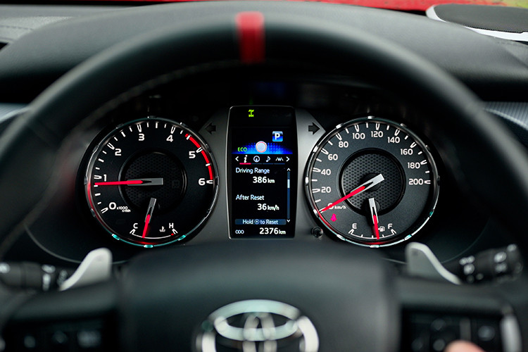 Về nội thất, bán tải hiệu năng cao Toyota Hilux GR Sport 2024 có những cải tiến như: vô lăng bọc da với lẫy chuyển số có đường chỉ màu đỏ ở trung tâm và dòng logo GR đặt ở đáy vô lăng.