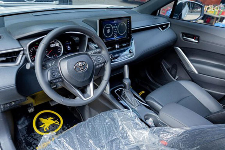 Nội thất của Corolla Cross sở hữu ghế ngồi bọc da chỉnh điện 8 hướng, ghế phụ chỉnh cơ 4 hướng, khởi động xe bằng nút bấm. Vô lăng dạng 3 chấu bọc da tích hợp với các nút chức năng. Phía sau vô-lăng là thiết kế bảng đồng hồ analog kết hợp màn hình đa thông tin 4,2 inch.