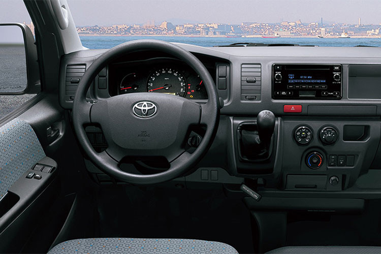 Một trong những ưu điểm khiến Toyota Hiace được đánh giá cao là phần thiết kế nội thất vô cùng rộng rãi và tiện nghi. Vô lăng thiết kế dạng 4 chấu, cùng việc trang bị trợ lái thủy lực khiến người sử dụng có cảm giác lái đầm hơn so với trợ lái điện. Trên bảng táp-lô có hệ thống thông tin giải trí với đầy đủ các kết nối như Bluetooth, AUX, USB, AM/FM...