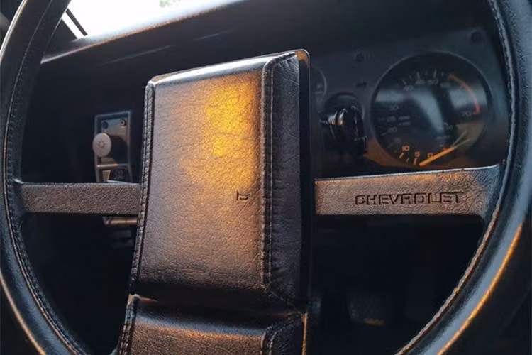 Vô lăng 3 chấu kép thiết kế lạ mắt này cũng đã được chủ nhân bọc lại da màu đen khá mới. Cụm đồng hồ của xe vẫn nguyên bản dạng cơ với thiết kế giống như nhiều mẫu xe cũ khác ra mắt cùng thập niên.