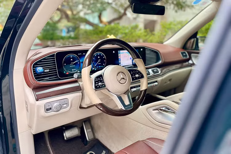Khoang nội thất của GLS Maybach là sự kết hợp tinh tế giữa nghệ thuật thủ công và công nghệ hiện đại. Ghế ngồi bọc da Nappa cao cấp với hai tông màu trắng kem Mahogany và nâu đỏ Macchiato Beige. Táp-lô và cụm điều khiển trung tâm được ốp gỗ Black Piano Lacquer với họa tiết "Flowing Lines" sang trọng.