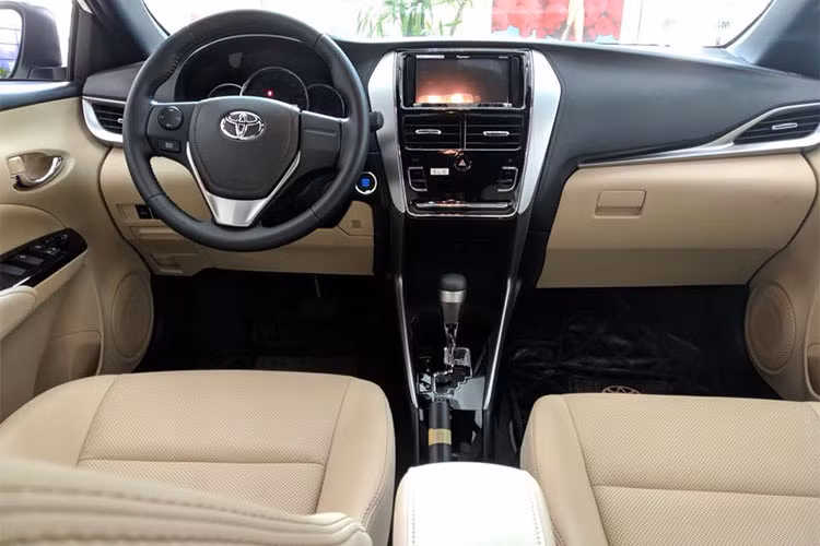 Bên trong Yaris 2018 bản cao cấp có những trang bị nổi bật như vô lăng bọc da, tích hợp phím chức năng và lẫy chuyển số thể thao, cụm đồng hồ Optitron, đầu đĩa CD/MP3, nút bấm khởi động máy, cổng USB/AUX, hệ thống kết nối Bluetooth, màn hình LCD chỉnh điều hòa, mở cửa không cần chìa khóa cũng như ghế sau gập 60:40.