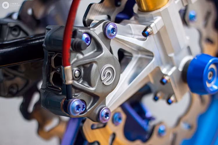 Sử dụng phuộc USD Ohlins lấy từ Ducati 1199 Panigale, tuy nhiên bản độ này có điểm độc đáo hơn nhiều chiếc Exciter 150 khác tại Việt Nam đó là không cắt phuộc do sử dụng tay lái trần. Hệ thống phanh trước cũng sử dụng toàn "hàng hiệu" với cặp đĩa Galfer và heo Brembo GP4RX.