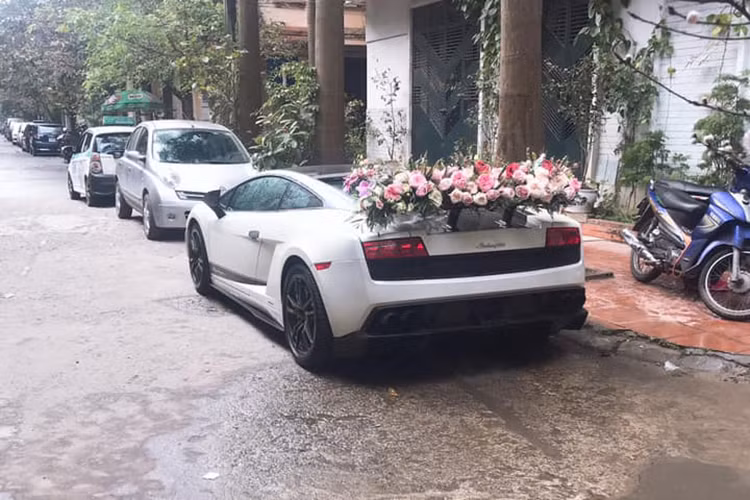 Lamborghini Gallardo LP570-4 Superleggera xuất hiện trên phố Hà Nội với bó hoa cưới cỡ lớn được gắn trên nắp capô phía trước đẹp mắt và cánh gió đuôi sau cũng xuất hiện thêm 1 bó hoa cưới khác trải dài sang 2 bên.