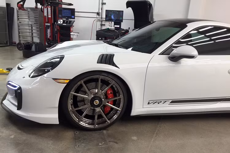 Thân xe được thiết kế khí động học với các hốc hút gió được bố trí hai bên với màu sơn đen nổi bật trên nền trắng của Porsche 911 Turbo.