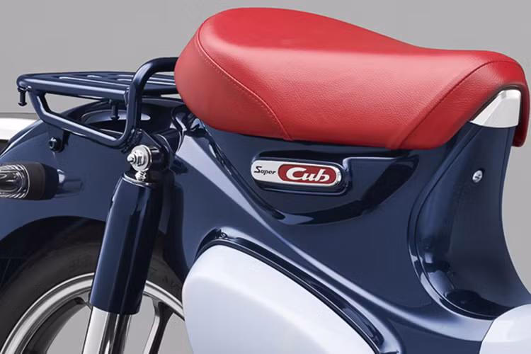 Chiếc xe vẫn giữ nguyên bộ yên đơn và giá đèo hàng giống như truyền thống của Super Cub. Bên dưới yên xe là logo Super Cub được thiết kế mamg hơi hướng cổ điển, đẹp mắt với mảng sơn đỏ trên nền mạ chrome.
