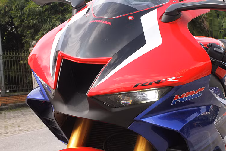 Thiết kế của Honda CRB1000RR-R SP 2020 mới sở hữu diện mạo hầm hố hơn hẳn CBR1000RR thế hệ cũ từng bán ra tại Việt Nam. Phần đầu xe dữ dằn với cụm đèn LED được vuốt xéo lên, bên trong là 4 thấu kính chia đều cho 2 bên. Ở giữa cụm đèn là hốc hút gió cỡ lớn - thiết kế quen thuộc trên những dòng siêu môtô đình đám.