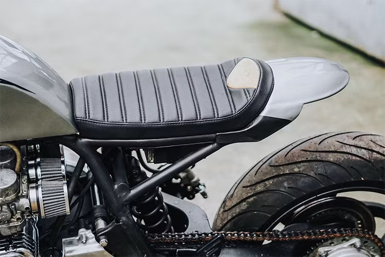 Bộ yên của xe được làm thủ công với các đường vân chần chỉ khá đẹp mắt, phần đuối với chắn bùn liền yên kéo dài hơn. Ở phía sau chiếc xe, người thợ độ tài hoa cũng khéo léo tích hợp một đèn hậu LED dưới gầm.