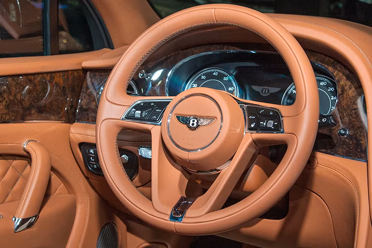 Ở phía dưới tại vị trí ngăn cách hai ghế trước là sự xuất hiện của cần số gắn logo chữ B, nút khởi động điện và loạt phím chọn chế độ lái. Vô-lăng trên xe là loại 3 chấu bọc da tích hợp một số phím chức năng cơ bản giống như trên những chiếc Bentley khác. Phía sau là 2 đồng hồ Analog và 1 màn hình cảm ứng hiển thị thông tin liên quan đến khả năng vận hành của xe. Phía trên là cửa sổ trời toàn cảnh Panorama đóng mở điện.