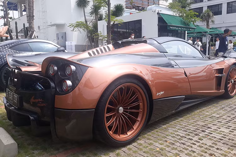 Ngoài màu đồng, bộ áo của chiếc siêu xe triệu đô Pagani Huayra Roadster tại Indonesia còn có các chi tiết sơn đen bóng và tất nhiên không thể thiếu sợi carbon ở cản trước, vỏ gương và cản sau xe.