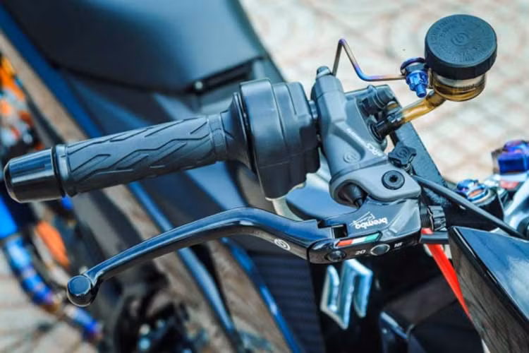 Ở phần đầu, xe được trang bị cùm tay thắng Brembo Corsa Corta đi kèm cùng bình dầu cùng thương hiệu màu xám khối trong suốt được cố định vào cùm thông qua một đoạn Titan nhỏ vô cùng cứng cáp và chống run lắc khi xe vận hành. Bộ cùm giúp kiểm soát phanh trước ổn định êm ái hơn so với mẫu tay Nissin nguyên bản.