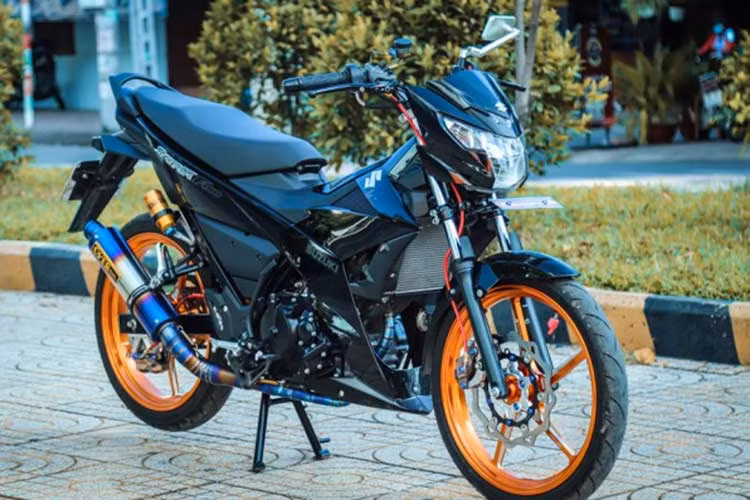 Dàn chân xế nổ Suzuki Raider độ này sở hữu mâm Racingboy 5 cây làm bằng chất liệu nhôm CNC vô cùng đẹp - dòng mâm này đã được Racingboy Malay cho ngưng sản xuất từ khá lâu và hiện nay những cặp hiếm hoi còn sót lại hoặc bán sang tay điều có giá trên 40 triệu đồng tùy tình trạng hiện mạo bên ngoài.