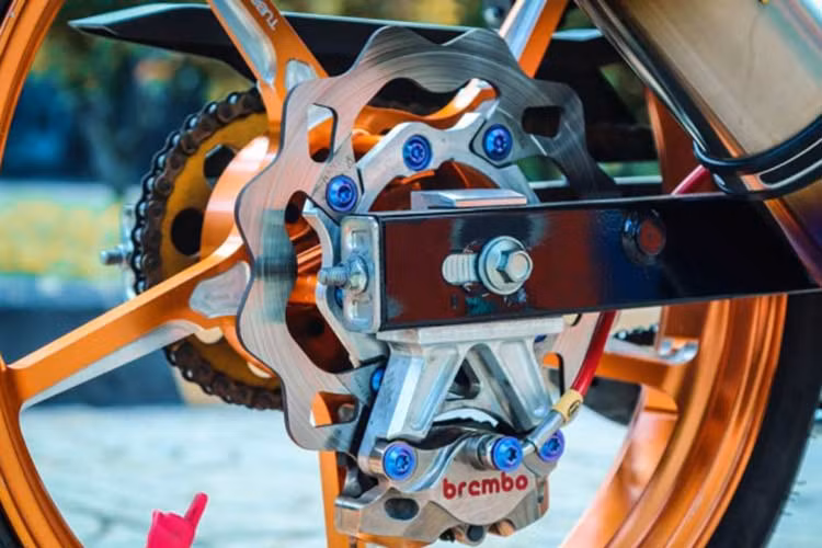 Hình ảnh hệ thống treo sau của xe do sử dụng heo dầu đối xứng nên phần đĩa Galfer phía sau phải làm thớt lòng CNC, nhằm kê đĩa ra ngoài tí xíu để tránh bị cạ heo vào mâm khi xe vận hành gây nguy hiểm cho người điều khiển. Phần pat CNC 90 độ này khá nay có thể xoay lên xoay xuống tùy theo sở thích của chủ xe.