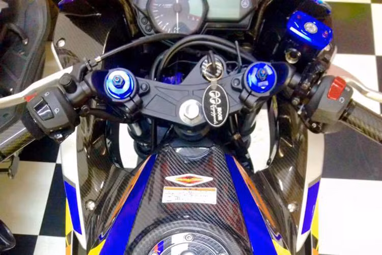 Dàn đầu xe với tay lái được độ lên carbon, cá chi tiết như bình dầu, ốc... được thay thế bằng các đồ chơi hàng hiệu màu xanh trùng với tông màu của đội Yamaha Movistar.