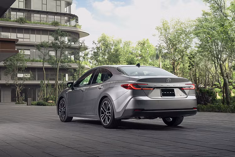 Ngoại thất của Camry 2025 được lột xác với thiết kế mới giàu cảm xúc, trẻ trung hơn, thể thao. Thiết kế phần đầu xe được lấy cảm hứng từ hình ảnh mạnh mẽ của “Cá mập đầu búa” với lưới tản nhiệt họa tiết kim cương mở rộng sang hai bên tạo nên vẻ ngoài bề thế và đầy uy lực.